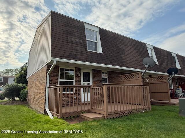 6328 Beechfield Dr, Lansing, MI 48911 - back of house featuring a gambrel roof, brick siding, roof with shingles, and a lawn