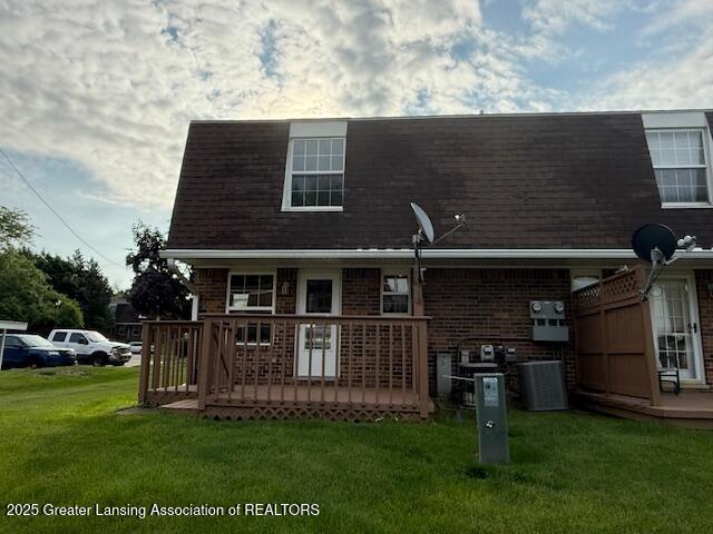 6328 Beechfield Dr, Lansing, MI 48911 - back of house with a lawn, a deck, brick siding, and a shingled roof