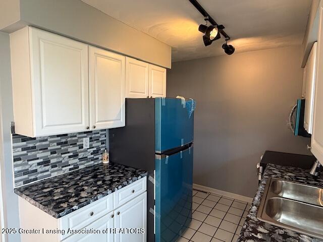6328 Beechfield Dr, Lansing, MI 48911 - kitchen featuring light tile patterned floors, tasteful backsplash, appliances with stainless steel finishes, white cabinetry, and track lighting