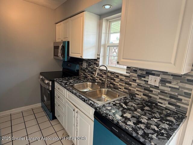 6328 Beechfield Dr, Lansing, MI 48911 - kitchen with black stove, stainless steel microwave, and white cabinetry