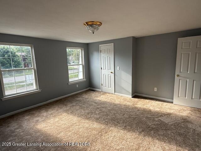 6328 Beechfield Dr, Lansing, MI 48911 - unfurnished bedroom with carpet floors and multiple windows