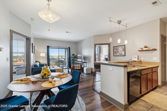 500 E Michigan Ave Unit 417, Lansing, MI 48912 - kitchen with a sink, open floor plan, brown cabinets, decorative light fixtures, and light stone countertops