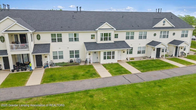 12947 Townsend Dr Unit 412, Grand Ledge, MI 48837 - view of property featuring cooling unit, a front yard, and a balcony