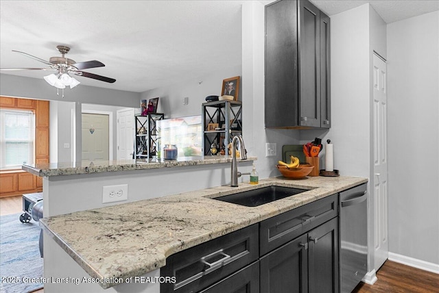 12947 Townsend Dr Unit 412, Grand Ledge, MI 48837 - kitchen with a sink, stainless steel dishwasher, dark wood-type flooring, ceiling fan, and light stone counters