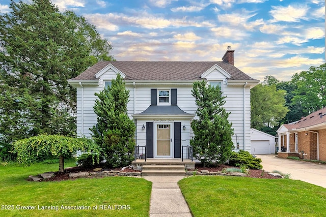 544 Collingwood Dr, East Lansing, MI 48823 - traditional home featuring a chimney, a front yard, an outdoor structure, and a garage