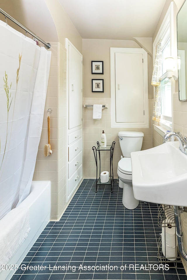 544 Collingwood Dr, East Lansing, MI 48823 - bathroom featuring tile walls, shower / tub combo with curtain, tile patterned floors, and wainscoting