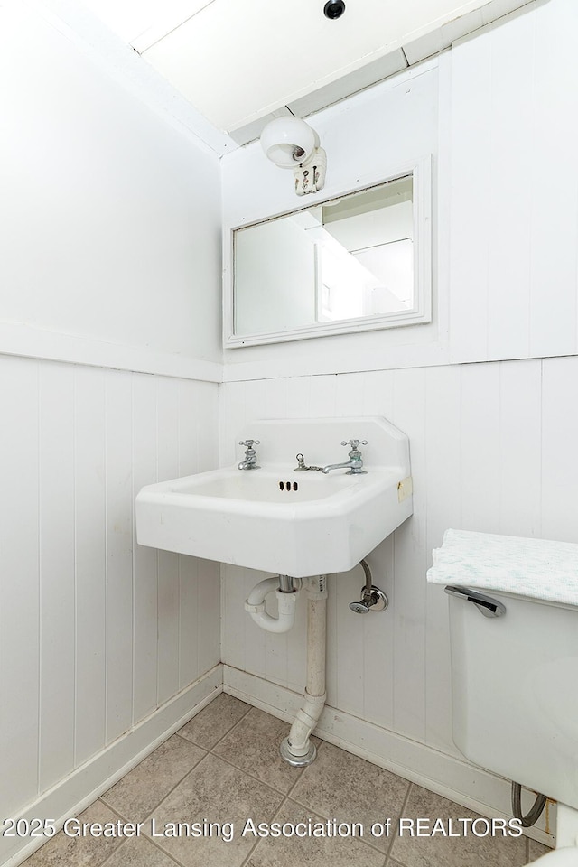 544 Collingwood Dr, East Lansing, MI 48823 - half bath with a wainscoted wall, a decorative wall, and tile patterned floors