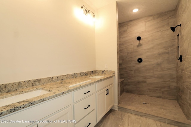 623 Aquila Dr, East Lansing, MI 48823 - bathroom featuring double vanity, tiled shower, and tile patterned floors