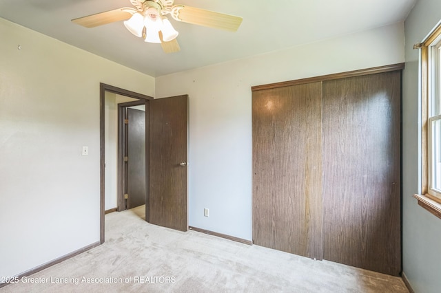 1802 Rockdale Ave, Lansing, MI 48917 - unfurnished bedroom featuring a closet, carpet flooring, baseboards, ceiling fan, and multiple windows