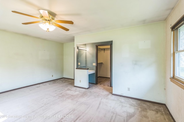 1802 Rockdale Ave, Lansing, MI 48917 - unfurnished bedroom featuring carpet flooring, baseboards, a walk in closet, and a ceiling fan