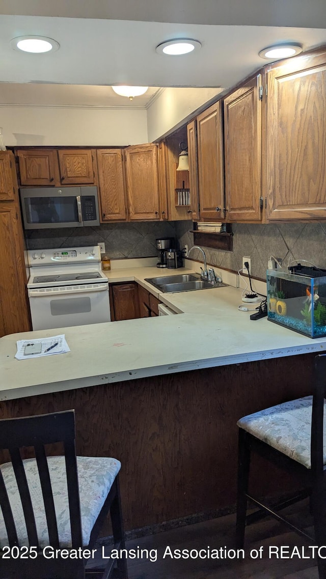 1515 Prospect St, Lansing, MI 48912 - kitchen featuring stainless steel microwave, white electric range, a sink, and light countertops