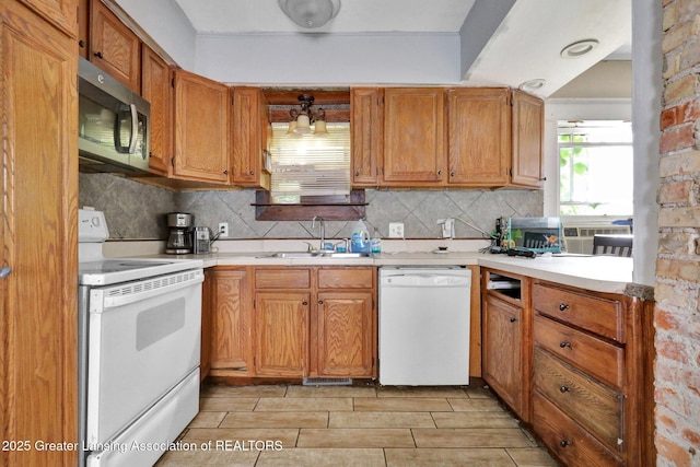 1515 Prospect St, Lansing, MI 48912 - kitchen with white appliances, tasteful backsplash, light countertops, and brown cabinetry