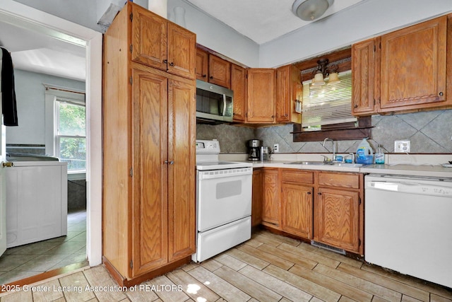 1515 Prospect St, Lansing, MI 48912 - kitchen featuring white appliances, light countertops, tasteful backsplash, brown cabinetry, and light wood-style floors