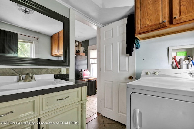 1515 Prospect St, Lansing, MI 48912 - laundry area featuring washer / clothes dryer, cabinet space, and dark tile patterned flooring