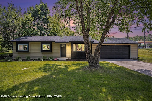 1808 Cadillac Ave, Lansing, MI 48917 - ranch-style house with driveway, a garage, a front lawn, and roof with shingles