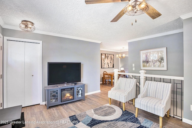 1808 Cadillac Ave, Lansing, MI 48917 - living area featuring ceiling fan, wood finished floors, a chandelier, a textured ceiling, and baseboards
