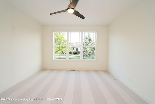 629 Aquila Dr, East Lansing, MI 48823 - spare room featuring light colored carpet, ceiling fan, and baseboards