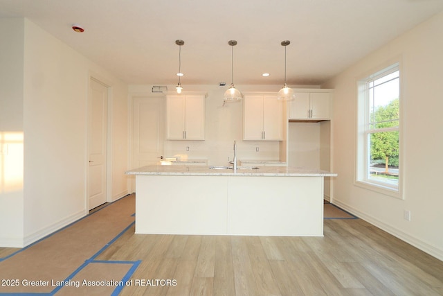 629 Aquila Dr, East Lansing, MI 48823 - kitchen with light wood-style flooring, white cabinets, a kitchen island with sink, and recessed lighting