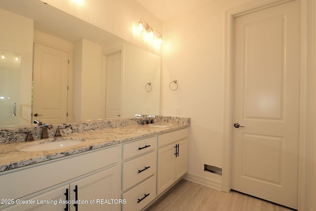 629 Aquila Dr, East Lansing, MI 48823 - bathroom with double vanity, baseboards, and wood finished floors