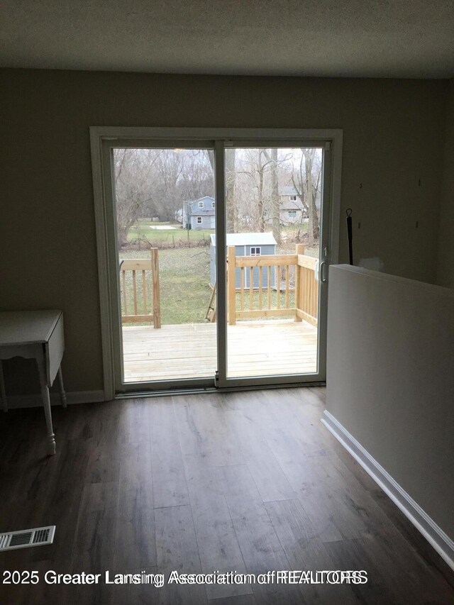 4615 Hughes Rd, Lansing, MI 48910 - unfurnished dining area featuring wood finished floors and baseboards