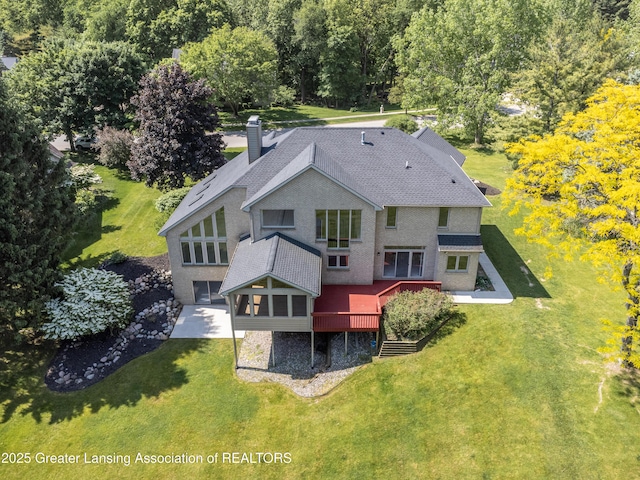 1120 Nautical Dr, Okemos, MI 48864 - back of property featuring a chimney, a lawn, a deck, and a shingled roof