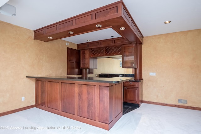 1120 Nautical Dr, Okemos, MI 48864 - kitchen featuring a peninsula, baseboards, carpet, dark countertops, and recessed lighting