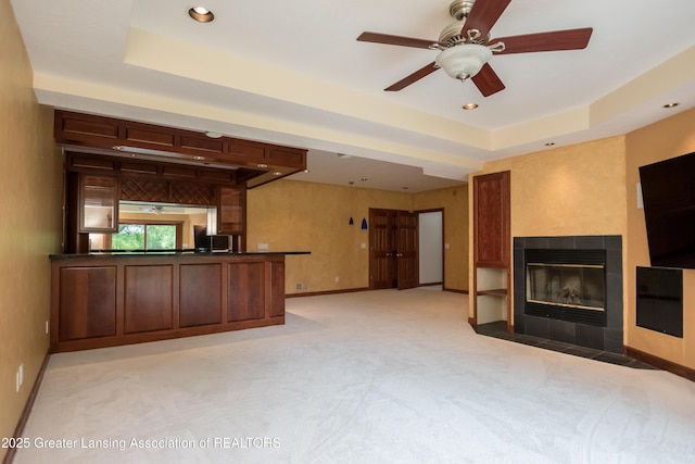 1120 Nautical Dr, Okemos, MI 48864 - unfurnished living room with a tray ceiling, light colored carpet, a fireplace, baseboards, and recessed lighting
