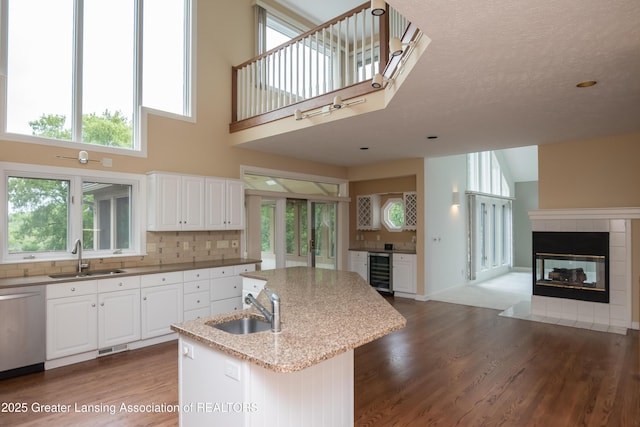 1120 Nautical Dr, Okemos, MI 48864 - kitchen with a sink, beverage cooler, stainless steel dishwasher, a kitchen island with sink, and a towering ceiling