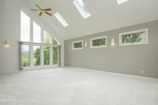 1120 Nautical Dr, Okemos, MI 48864 - spare room with high vaulted ceiling, light carpet, baseboards, a skylight, and ceiling fan