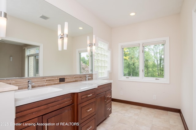 1120 Nautical Dr, Okemos, MI 48864 - bathroom featuring double vanity, decorative backsplash, baseboards, and recessed lighting