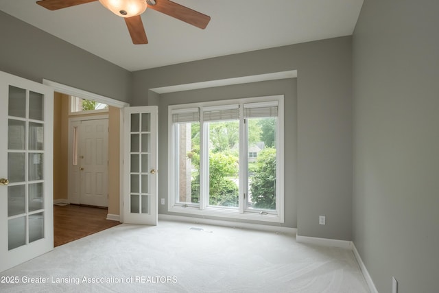 1120 Nautical Dr, Okemos, MI 48864 - empty room featuring carpet floors, baseboards, a ceiling fan, and french doors
