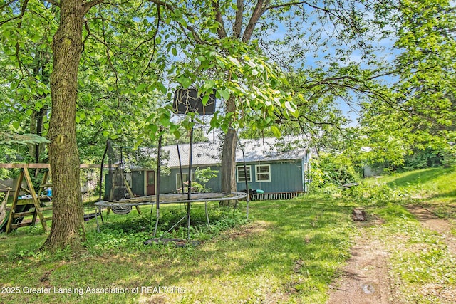 3770 E Frost Rd, Webberville, MI 48892 - view of grassy yard featuring a trampoline