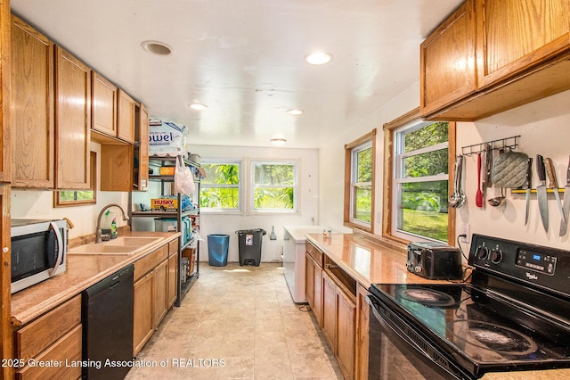 3770 E Frost Rd, Webberville, MI 48892 - kitchen featuring black appliances, a sink, light countertops, brown cabinets, and recessed lighting