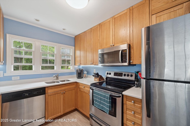 942 W Grand River Ave, East Lansing, MI 48823 - kitchen featuring stainless steel appliances, light countertops, ornamental molding, and light wood-type flooring