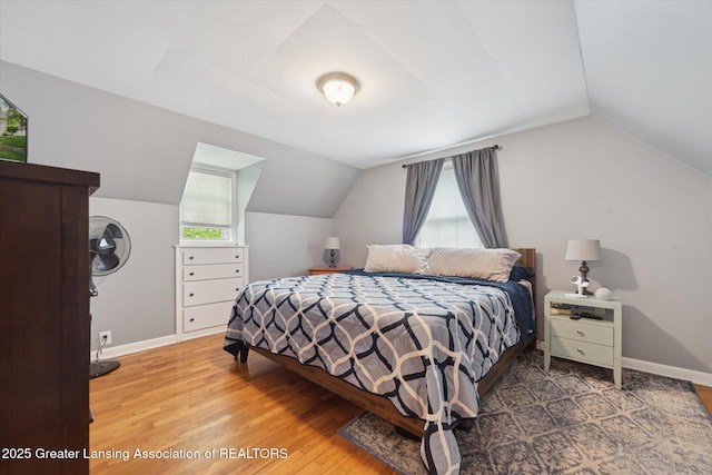 942 W Grand River Ave, East Lansing, MI 48823 - bedroom featuring wood finished floors and vaulted ceiling