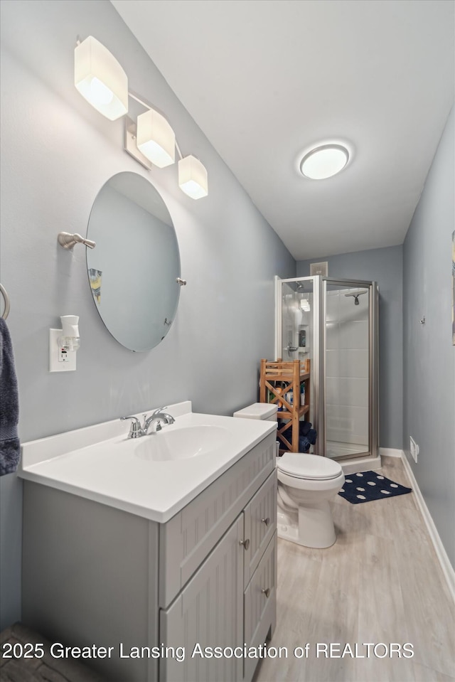 942 W Grand River Ave, East Lansing, MI 48823 - full bathroom featuring wood finished floors, vanity, and a shower stall