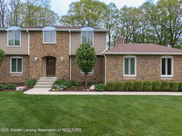 6108 Skyline Dr, East Lansing, MI 48823 - view of front of property featuring a chimney, a front lawn, and brick siding