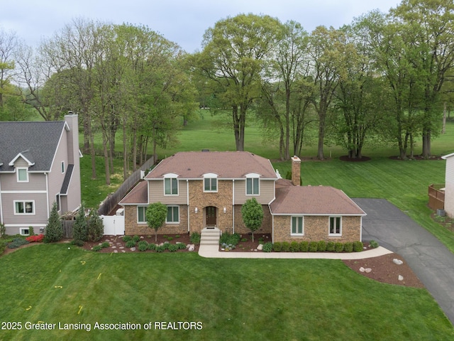 6108 Skyline Dr, East Lansing, MI 48823 - view of front facade with brick siding, a chimney, and driveway