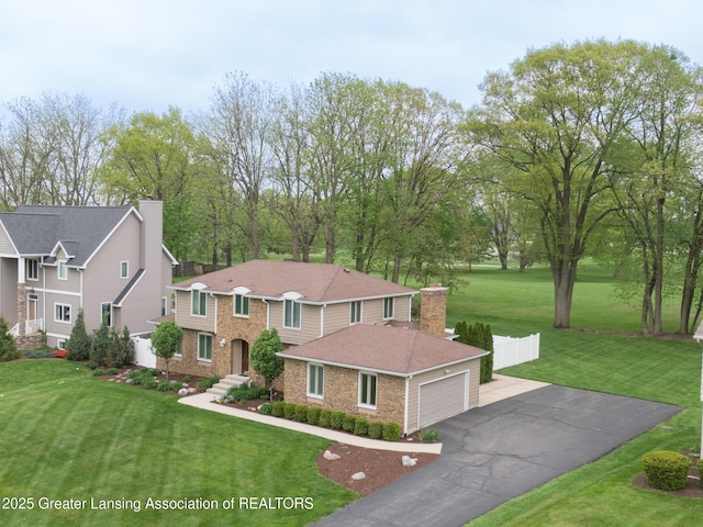 6108 Skyline Dr, East Lansing, MI 48823 - traditional-style home with brick siding, asphalt driveway, a front yard, and an attached garage