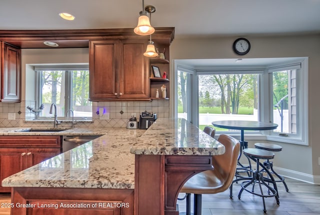 6108 Skyline Dr, East Lansing, MI 48823 - kitchen featuring a sink, healthy amount of natural light, tasteful backsplash, baseboards, and recessed lighting