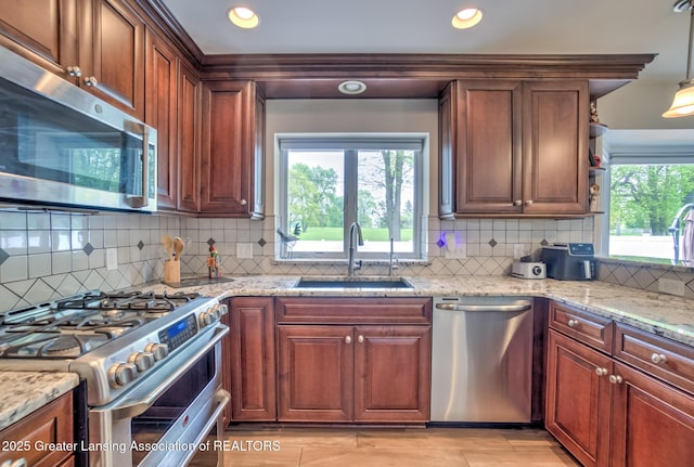 6108 Skyline Dr, East Lansing, MI 48823 - kitchen featuring appliances with stainless steel finishes, a sink, light stone counters, backsplash, and recessed lighting