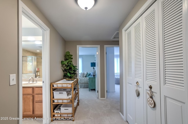 6108 Skyline Dr, East Lansing, MI 48823 - hall featuring light colored carpet, a sink, and baseboards