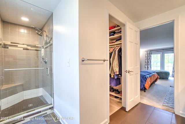 6108 Skyline Dr, East Lansing, MI 48823 - ensuite bathroom featuring a shower stall, recessed lighting, tile patterned floors, a spacious closet, and baseboards