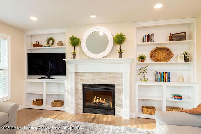 5871 Green Rd, Haslett, MI 48840 - living room with a stone fireplace, wood finished floors, built in shelves, and recessed lighting