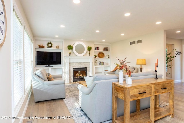 5871 Green Rd, Haslett, MI 48840 - living area featuring light wood finished floors, recessed lighting, a stone fireplace, and built in shelves