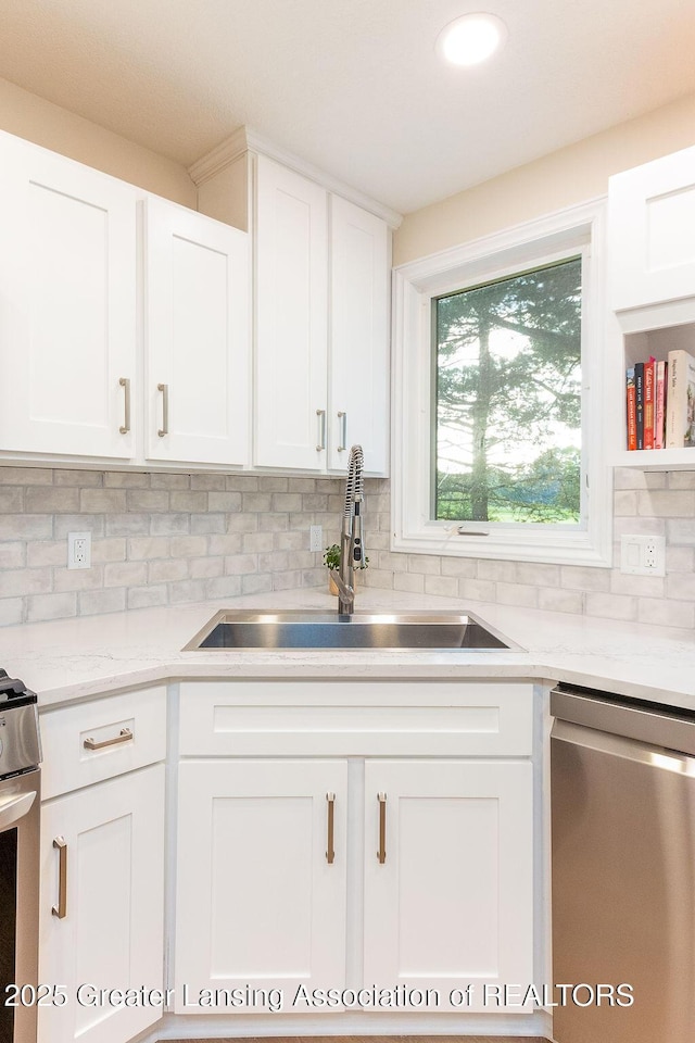 5871 Green Rd, Haslett, MI 48840 - kitchen featuring appliances with stainless steel finishes, white cabinetry, backsplash, light stone countertops, and recessed lighting