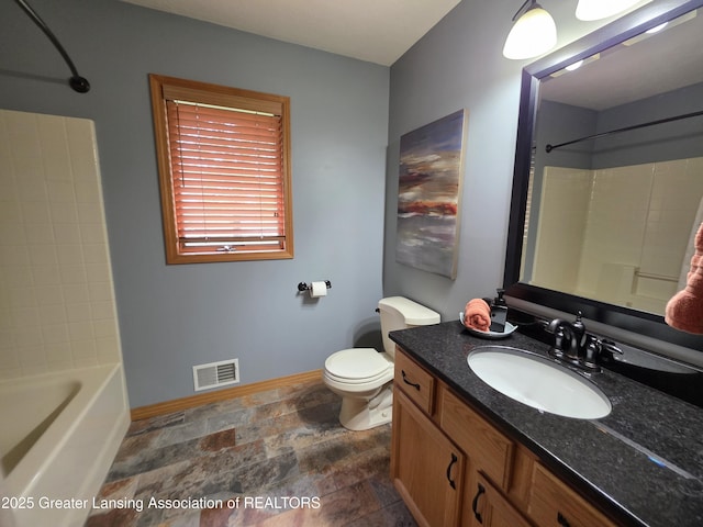 2380 S Waverly Rd, Eaton Rapids, MI 48827 - bathroom featuring baseboards, vanity, toilet, stone finish flooring, and washtub / shower combination