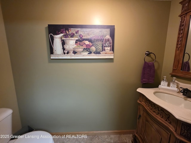 2380 S Waverly Rd, Eaton Rapids, MI 48827 - bathroom featuring toilet, vanity, and baseboards
