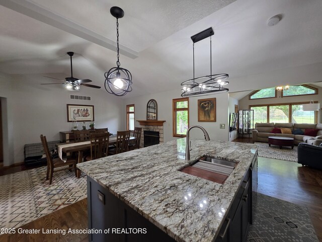 2380 S Waverly Rd, Eaton Rapids, MI 48827 - kitchen featuring vaulted ceiling, a sink, open floor plan, dark wood finished floors, and healthy amount of natural light