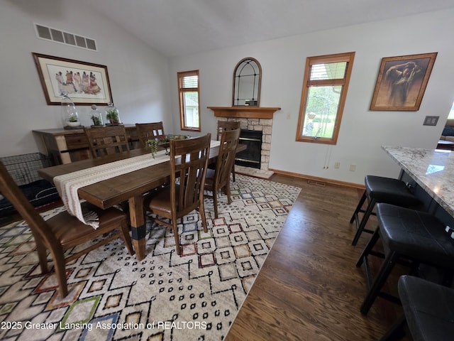 2380 S Waverly Rd, Eaton Rapids, MI 48827 - dining room with wood finished floors, lofted ceiling, a fireplace, and baseboards